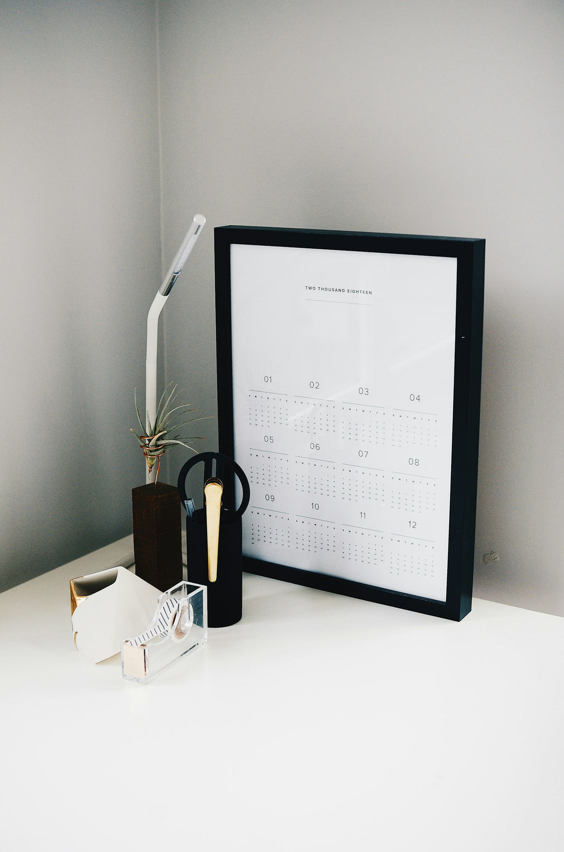 A simple desk calendar in a black frame on a table