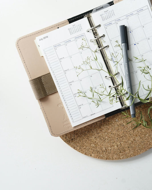 A pen resting on an open calendar planner