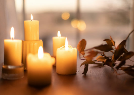 Lit pillar candles on a wooden table in warm evening light