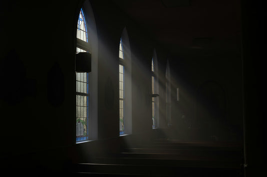 Sunlight streaming through windows into a quiet dark room