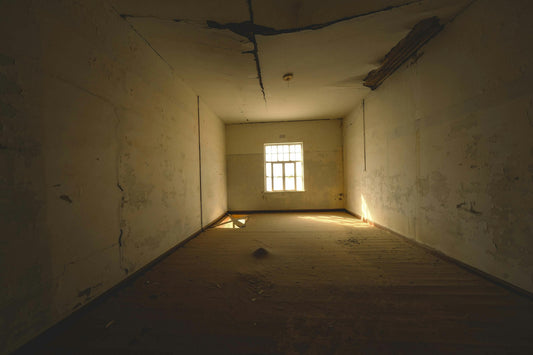An empty, sunlit room with worn walls